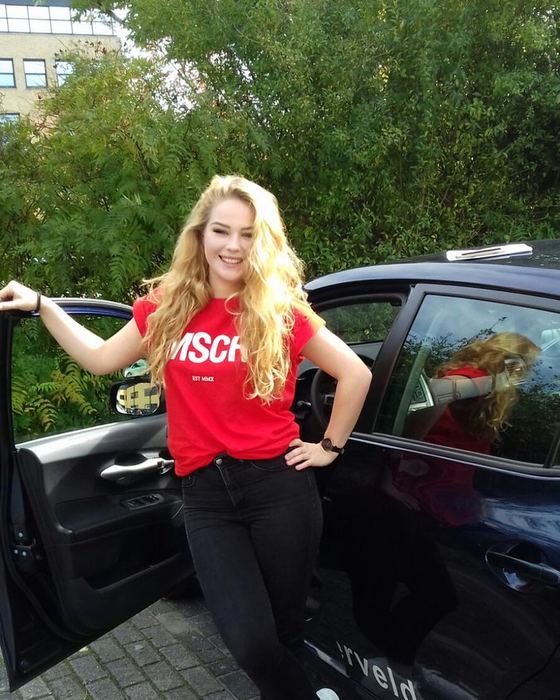 Ingrid vd Pol uit Berghuizen bij de lesauto na haar examen