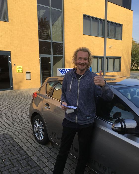 Roland Lier uit Ruinerwold bij de lesauto na zijn examen