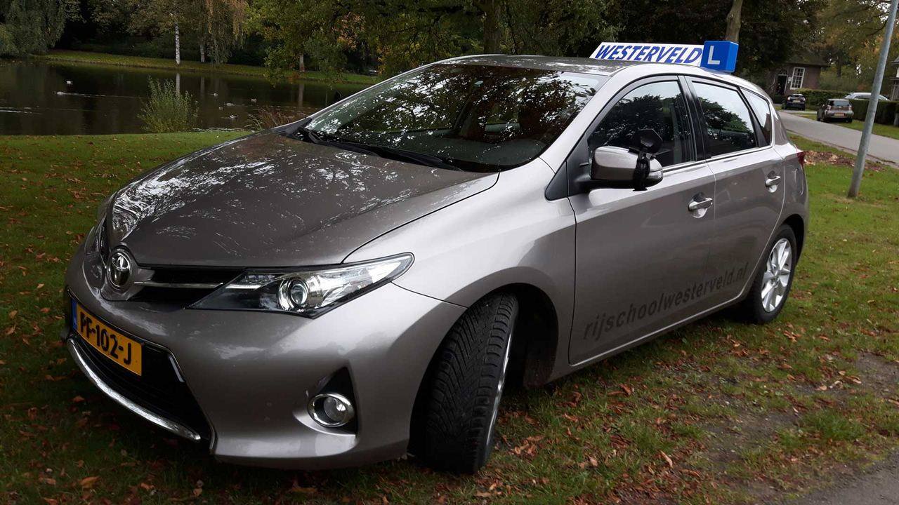 Lesauto van Rijschool Westerveld met lesbord aan de vijver in Meppel